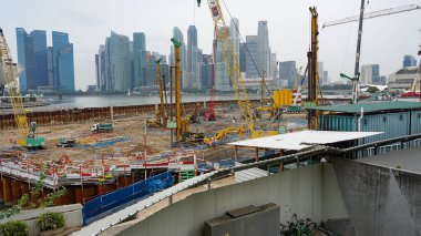 Singapur - 22 Ocak 2025: Singapur 'daki marina körfezi kumları ufuk çizgisi. Körfez kıyısındaki Gardens 'ta logoları görülen iki büyük bankanın gökdelenleri DBS Bank ve HSBC Bank ve Maybank' tır..