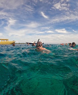 Gili Air, Endonezya - 15 Ocak 2025: Bir sürat teknesi ve muzun, babanaboat gezileri ve şnorkelle yüzmek için yolcuları taşıdıktan sonra Gili sahiline yanaştığı görüldü..