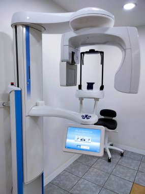 Kyiv, Ukrayna - 16 Haziran 2024: Diş Konisi bilgisayar tomografisi Planmeca ve klinikte koruyucu pelerin