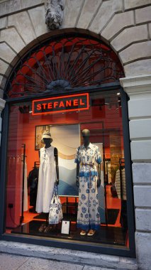 Verona, İtalya - 14 Mayıs 2025: İtalya 'nın Verona kentindeki kentsel caddede neon kırmızı desenli çelik mağaza önü tabelası.