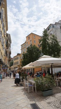 Kerkyra, Korfu, Yunanistan - 9 Mayıs 2025: Yunanistan 'daki Korfu adasındaki eski Korfu Kasabası' ndaki tarihi binaların yakınlarına giden insanlar