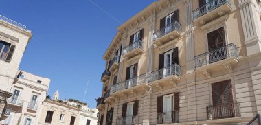 Bari 'deki beyaz binanın balkonunda.