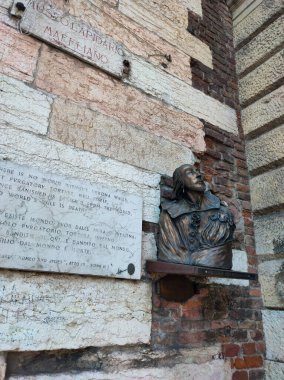 Verona, İtalya - 12 Mayıs 2025: William Shakespeare 'in bükülmesi ve duvarında Romeo ve Juliet' in sözlerinin yazılı olduğu bir mermer tahta, İtalya 'nın Verona kentindeki Lapidario Maffeiano Müzesi' nin girişinde