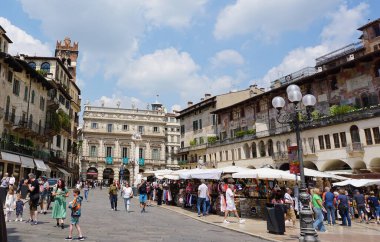 Verona, İtalya - 12 Mayıs 2025: Citta Antica Meydanı 'ndaki Piazza Delle Erbe Meydanı' na giden insanlar, eski evler Case dei Mazzanti, Torre dei Lamberti Kulesi, Verona 'daki Palazzo della Ragione Sarayı