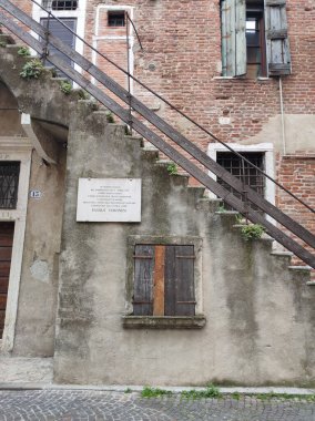 Verona, İtalya - 12 Mayıs 2025: Ahşap bir merdiveni ve 1797 Pasque Veronesi ayaklanmasını anan tarihi bir plaketi olan bir köy duvarı. Verona 'nın eski kasabasının sessiz, büyüleyici bir köşesi