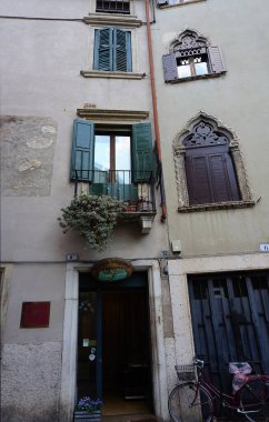 Verona, İtalya - 12 Mayıs 2025: Ortaçağ duvarı balkonunda çiçekli güzel geleneksel İtalyan binası