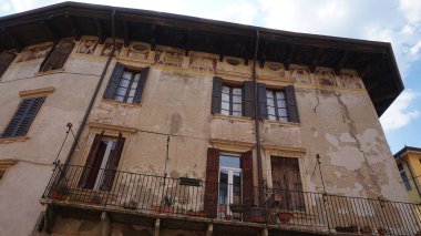 Verona, İtalya - 12 Mayıs 2025: Ortaçağ duvarı balkonunda çiçekli güzel geleneksel İtalyan binası