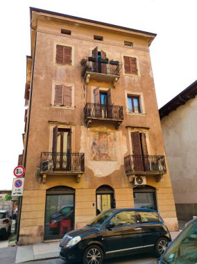 Verona, İtalya - 12 Mayıs 2025: Ortaçağ duvarı balkonunda çiçekli güzel geleneksel İtalyan binası