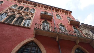 İtalya, Verona 'da ortaçağ duvarının balkonunda çiçekleri olan güzel geleneksel İtalyan binası.
