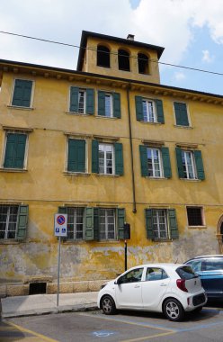 Verona, İtalya - 12 Mayıs 2025: Ortaçağ duvarı balkonunda çiçekli güzel geleneksel İtalyan binası