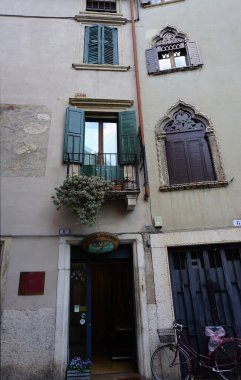 Verona, İtalya - 12 Mayıs 2025: Ortaçağ duvarı balkonunda çiçekli güzel geleneksel İtalyan binası