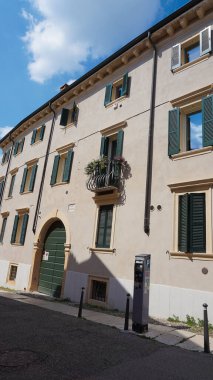 Verona, İtalya - 12 Mayıs 2025: Ortaçağ duvarı balkonunda çiçekli güzel geleneksel İtalyan binası