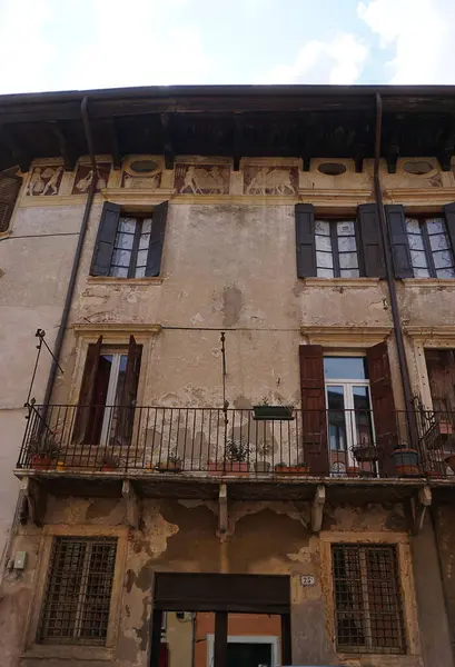 Verona, İtalya - 12 Mayıs 2025: Ortaçağ duvarı balkonunda çiçekli güzel geleneksel İtalyan binası