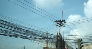 Elektrik direklerine bağlı kaotik bir elektrik hattı karışıklığı.