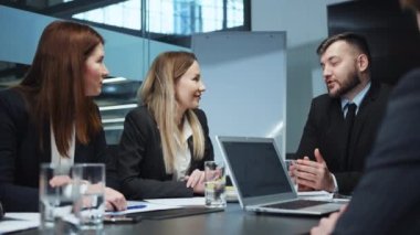 İş toplantısındaki insanlar, masada oturan ve iletişim kuran yöneticiler, yeni projenin detaylarını veren CEO. Meslektaşlar fikir paylaşımı, plan stratejisi. Takım çalışması kavramı