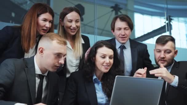 オフィシャルウェアのビジネスマンは オンライン取引を見て 幸せを感じ 高5を与える ノートパソコンの前のオフィスで一緒に集まります 成功チーム — ストック動画