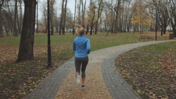 身穿秋季运动服的慢动作女慢跑者跑到外面 在拍摄到女慢跑者在外面运动之后 健康的概念 — 图库视频影像
