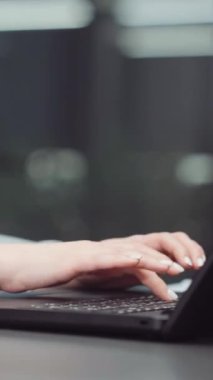 Dikey ekran: elleri dizüstü bilgisayarda yazan ve tablet üzerindeki ekranları aşıran kızıl saçlı kadının elleri. Ofiste oturup araştırma yapan şirket analistinin kısmi görüşü. İş kavramı