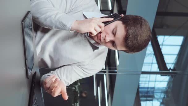 Süveter Giyen Genç Adam Ofiste Çalışıyor Dizüstü Bilgisayar Kullanıyor Telefonla — Stok video