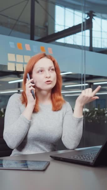 Vertical Screen Rothaarige Geschäftsfrau Berät Telefonisch Büro Laptop Und Tablet — Stockvideo