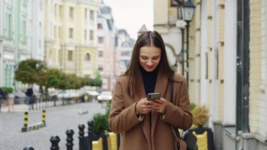 Akıllı telefonuyla SMS yazan neşeli bir kadın. Sokakta rüya gibi bir kadın sohbeti. Blogcu yeni sosyal medya aboneliği yapıyor, internetten alışveriş yapıyor, internetten ürün sipariş ediyor. Taşınabilir bağımlılık kavramı
