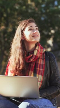 Genç romantik kadın fular günü hayal kuruyor ve gün batımında dizüstü bilgisayarda çalışıyor. Serbest çalışan bir kadın, kompozisyon yazan bir blog yazarı, web sitesi için blog yazıyor. İnternet serbest meslek seçimi kavramı