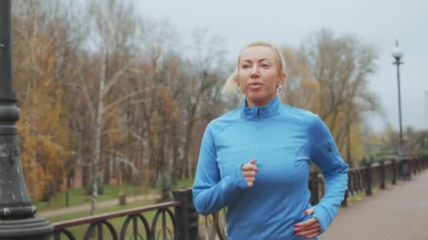 Fit Mulher Loira Vestindo Camisa Azul Esportes Correndo Parque Perto — Vídeo de Stock