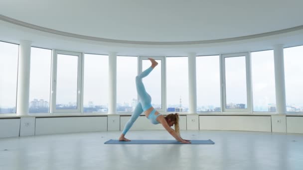 스튜디오에서 트위스트 워리어 포즈를 취하며 연습을 의개와 균형을 운동을 — 비디오