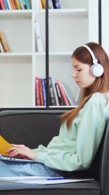 Dikey Ekran: Genç kız kulaklıkla müzik dinliyor ve dizüstü bilgisayarla çalışıyor. Uzaktan çalışan serbest çalışan biri. Öğrenci internette geziniyor ve kütüphanede şarkı söylüyor. Uzak çalışma kavramı