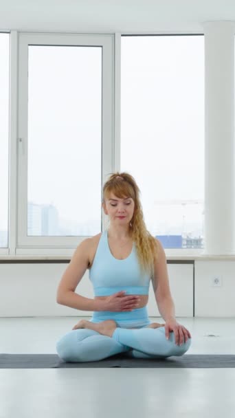 Vertical Screen Woman Blue Sportswear Doing Breathing Exercise Lotus Pose — стокове відео