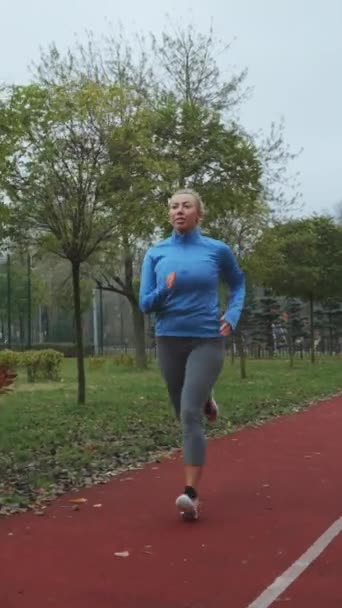 Vertical Screen Adult Blonde Woman Wearing Blue Sports Jacket Jogging — Stockvideo