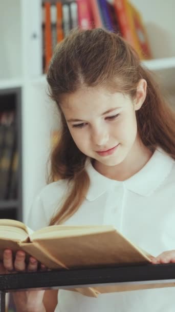 Vertical Screen Smiling Child Standing Book Bookshelves Reading Portrait Smart — Vídeo de stock