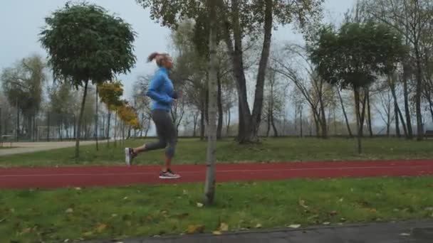 Young Blonde Woman Wearing Blue Sports Jacket Jogging Track Autumn — Stock video