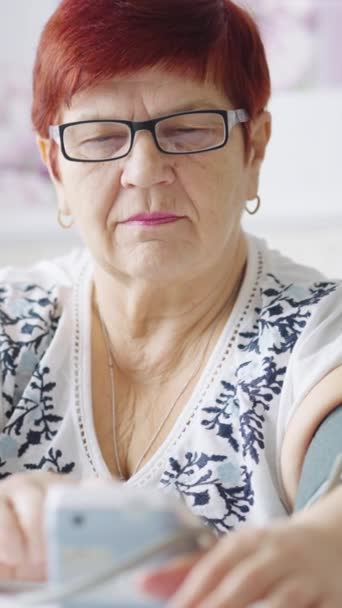 Vertical Screen Senior Woman Wearing Eyeglasses Sitting Home Measuring Blood — Stockvideo