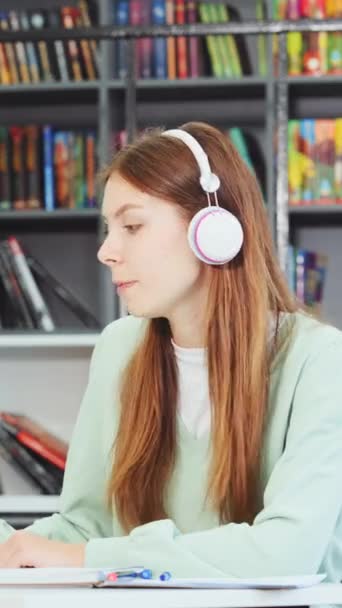 Vertical Screen Кавказька Студентка Навушників Навчаються Бібліотеці Слухаючи Музику Працюючи — стокове відео