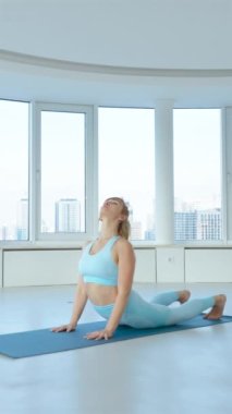 Dikey Ekran: yoga stüdyosunda Kobra Pozu ve Aşağı Yüzlü Köpek pozları veren formda bir kadın. Yogi dişisi panoramik pencereli Bhujangasana ve Adho Mukha Svanasana taklidi yapıyor. Sağlıklı yaşam tarzı kavramı