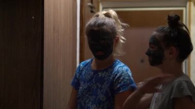 Yüzünde çamur maskeleri olan neşeli gençler evde dans edip eğleniyorlardı. Kozmetik ameliyatlarından hoşlanan mutlu ergenlik çağındaki kızların portresi. Cilt bakımı kavramı