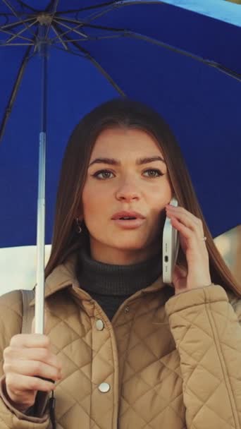 Verticaal Scherm Aantrekkelijke Jonge Vrouw Met Blauwe Paraplu Aan Telefoon — Stockvideo