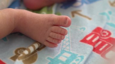 Yakın plan, küçük çıplak ayak ve yeni doğmuş bebeğin parmakları. Yumuşak bacaklı, çarşafta dinlenen sakinlik hisseden. Annelik, aile, bakım ve doğum kavramı