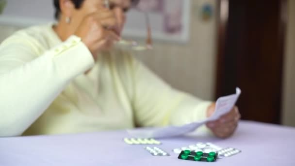 Mujer Mayor Que Pone Anteojos Lee Hoja Información Medicina Prescrita — Vídeo de stock
