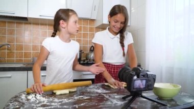 Genç vlogcular yemek blogu için merdaneyle hamuru saran video içeriği kaydediyor. Neşeli kızlar sırlarını canlı yayında paylaşırlar. İletişim, sağlıklı yiyecekler, el yapımı, ağ konsepti