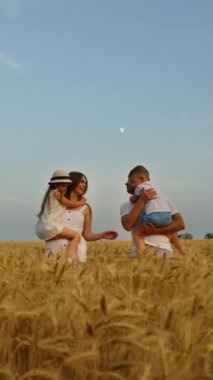 Dikey Ekran: Ebeveynler küçük çocukları kollarında tutuyor ve buğday tarlasında yavaş çekimde yürüyor, öpüşüyor ve gülümsüyor. İzleme mutlu aile doğada birlikte vakit geçiriyor. Aşk kavramı