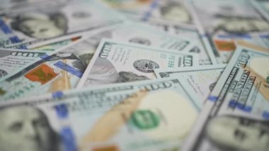 Masaya dağılmış yüz dolarlık banknotlar. Amerika 'nın yüz dolarlık banknotlarıyla arka planda dönüyor. İş ve finans kavramı