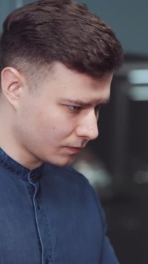 Dikey Ekran: Mavi gömlekli yakışıklı adam ofiste çalışıyor, istatistikleri kontrol ediyor ve dizüstü bilgisayarda daktilo yazıyor. Şirket yöneticisinin iş yerindeki el kamerası görüntüleri. İş kavramı