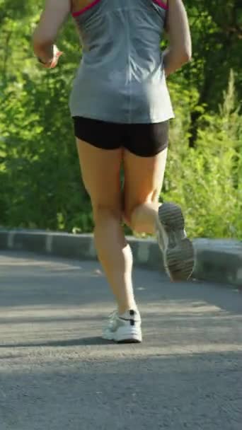 Κάθετη Οθόνη Γυναικεία Πόδια Φορώντας Αθλητικά Sneakers Που Τρέχουν Ασφαλτοστρωμένο — Αρχείο Βίντεο