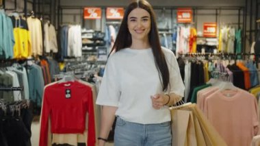 Alışveriş merkezinde alışveriş torbalarıyla yürüyen gülümseyen kadınlar. Yeni kıyafetler aldıktan sonra bir kadın. Alışverişkolikler malları mecburi olarak satın alırlar. Alışveriş kavramı