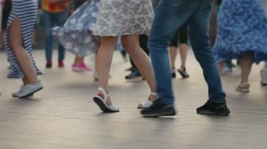 Closeup feet of dancers on summer terrace. People actively and joyfully dancing and spending their free time. Concept of active leisure
