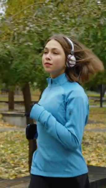 Pionowy Ekran Sportowa Kobieta Nosząca Słuchawki Jogging Jesiennym Parku Rano — Wideo stockowe