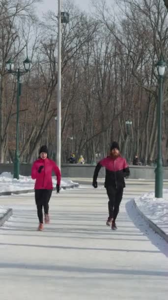 Ekran Pionowy Mężczyzna Kobieta Różowej Czarnej Odzieży Sportowej Biegający Parku — Wideo stockowe