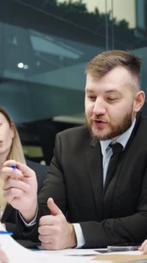 Dikey ekran: Bir grup iş adamı ofiste oturup projeyi tartışıyor, iş arkadaşları fikir paylaşıyor, idari yöneticilerin ekip çalışması beyin fırtınası yapıyor, planlama stratejisi geliştiriyor